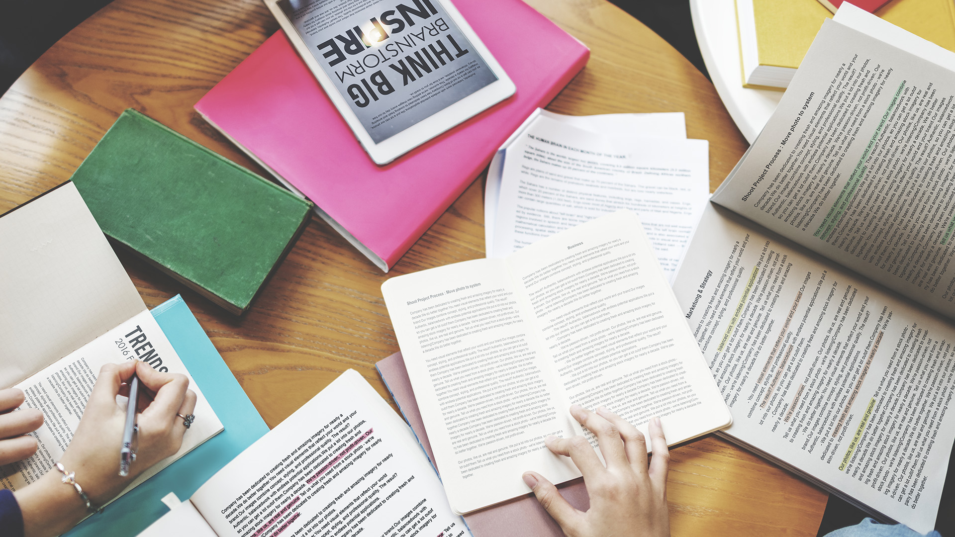 Team members using research books and digital media  and 